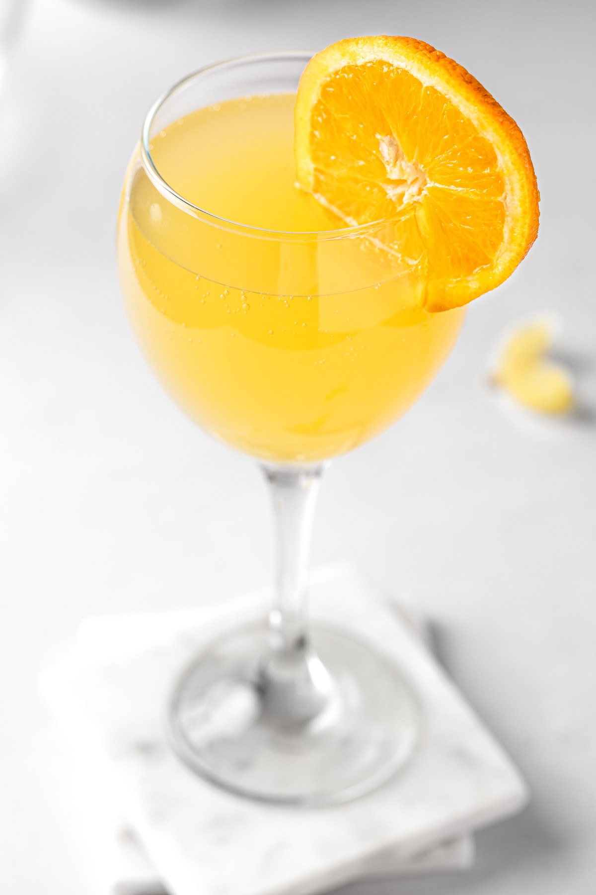 An agua de valencia cocktail, garnished with an orange slice.