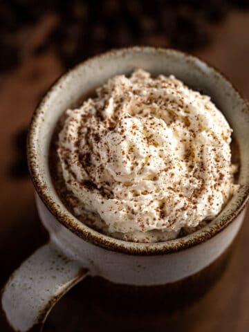 Overhead view of baileys iced coffee, topped with whipped cream an a sprinkle of cocoa powder.