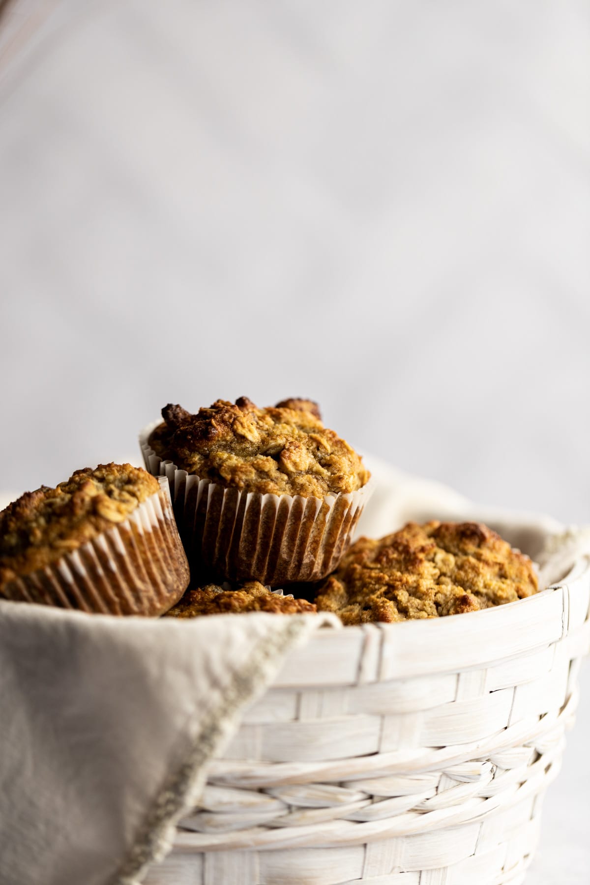 Up close shot of golden almond flour muffins in a white basket.