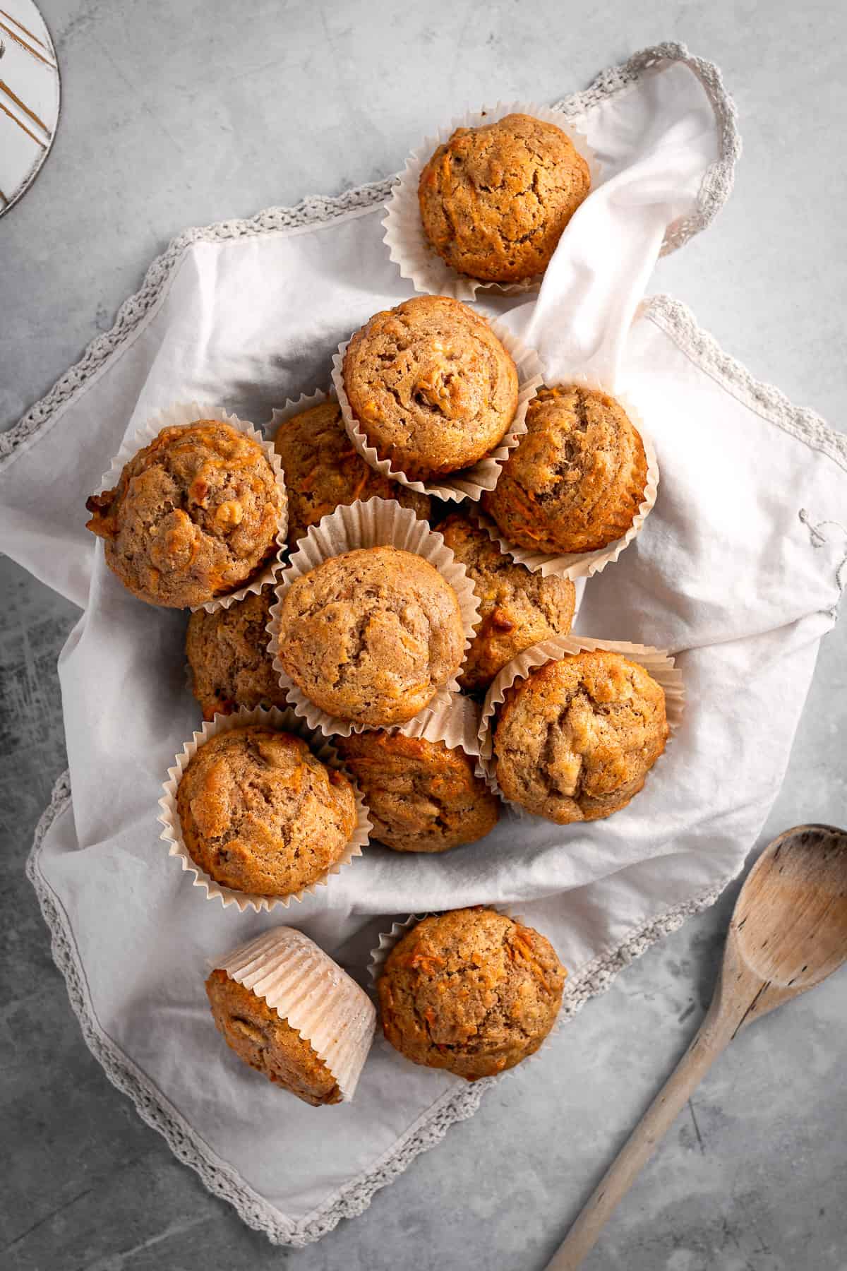 Overhead view of a bunch of banana carrot muffins on a beige napkin.