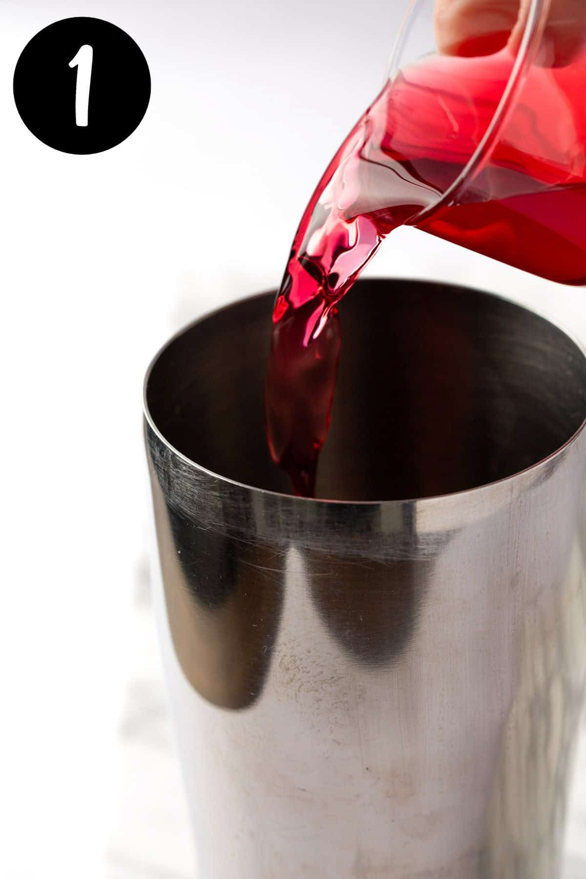 Pouring the cranberry juice into the cocktail shaker.