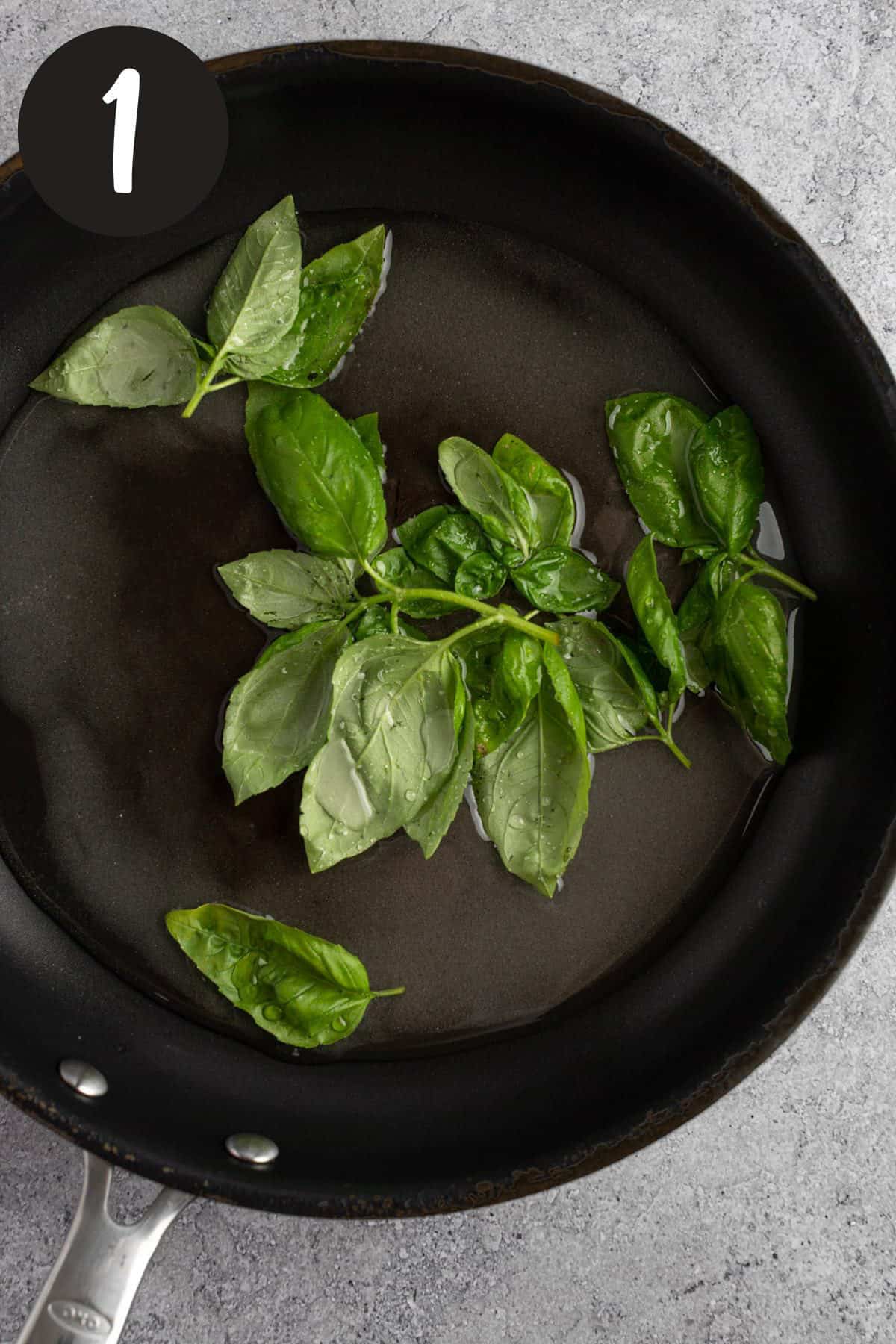 Heating the basil leaves, sugar and water together in a saucepan.