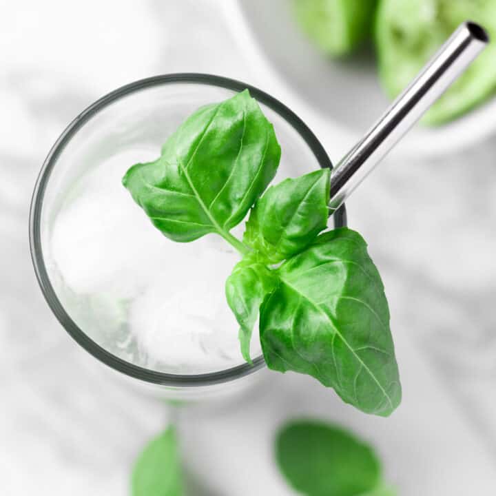 Overhead view of a basil mojito garnished with fresh basil leaves.