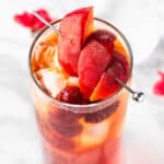 Overhead view of a bellini peach raspberry iced tea garnished with peach slices.