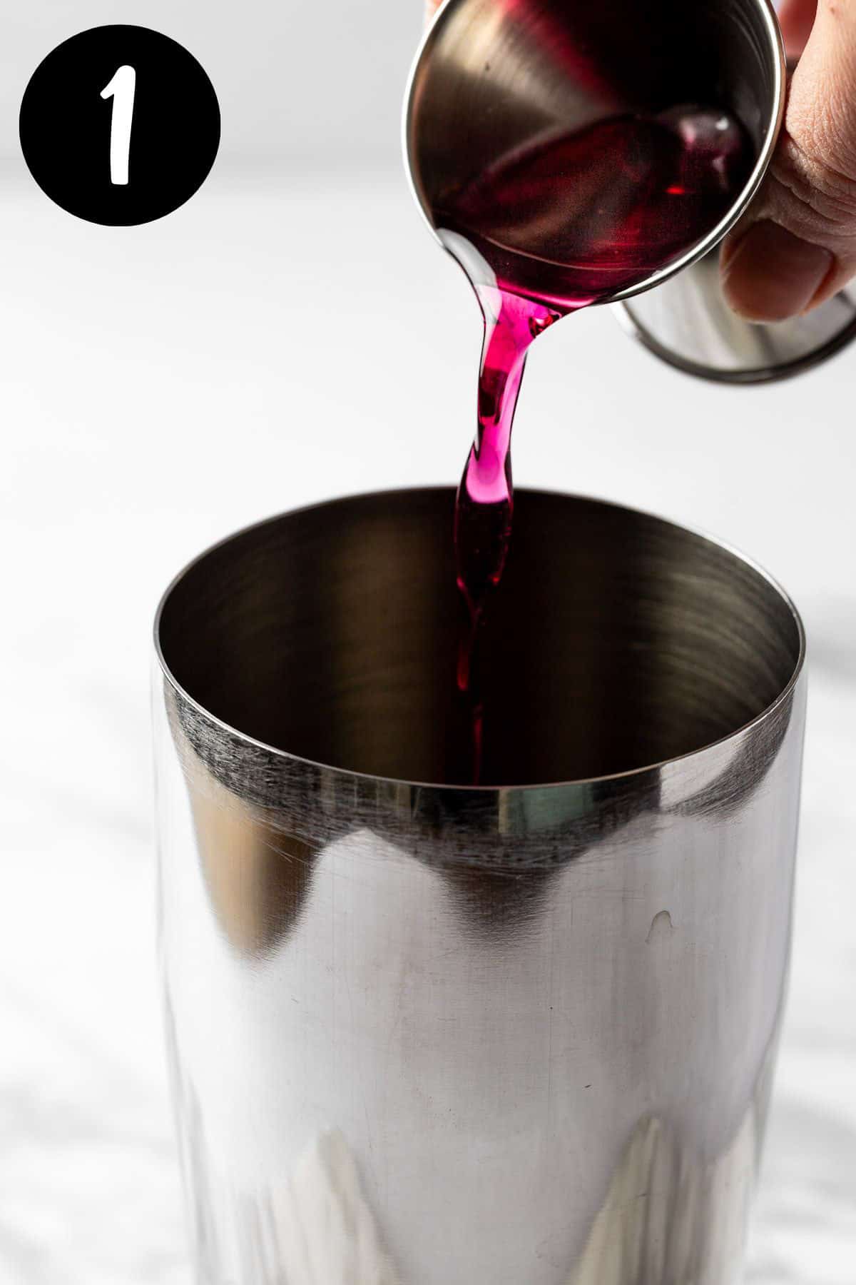 Pouring the blueberry syrup into a cocktail shaker.