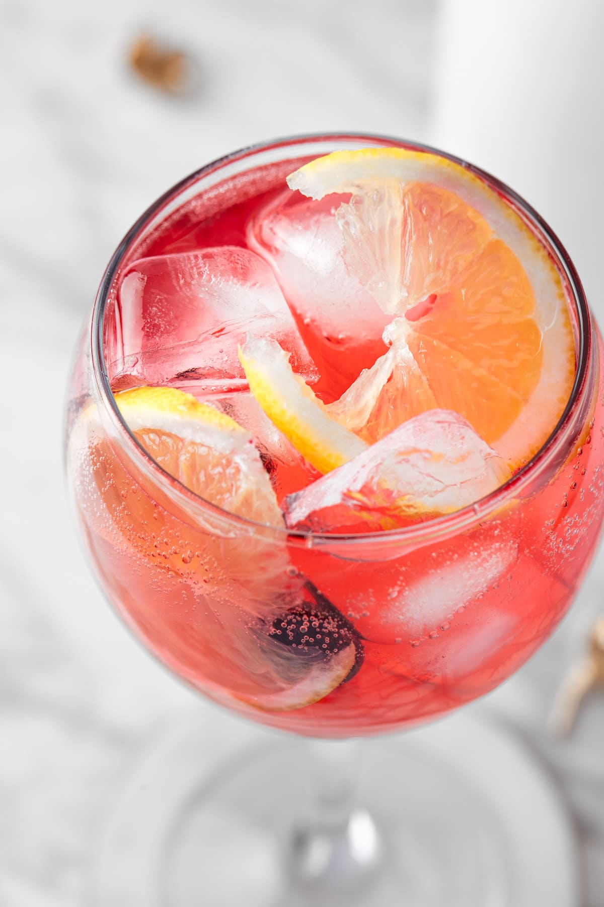 A blueberry lemonade cocktail garnished with lemon slices and blueberries.