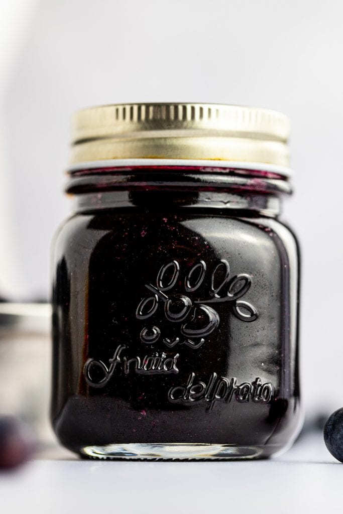 Close up photo of a jar of blueberry simple syrup.