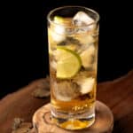 A bourbon rickey cocktail on a wooden serving board.