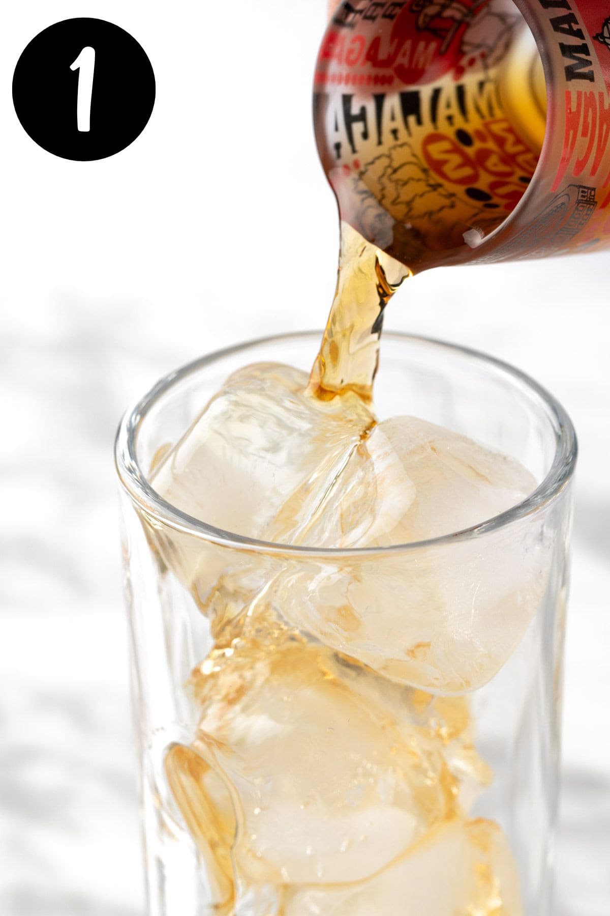 Pouring a shot of bourbon into the cocktail glass.