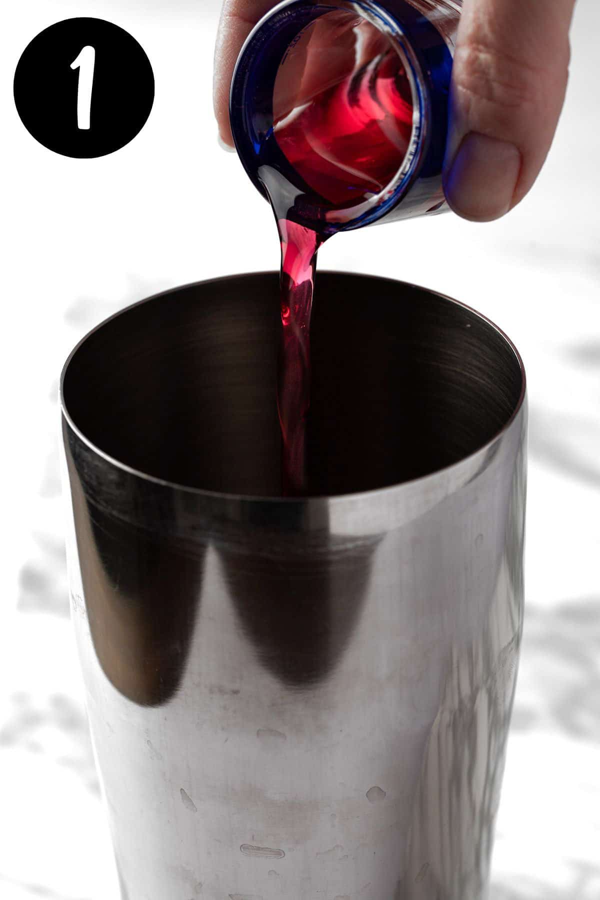 Pouring the blackberry syrup into the cocktail shaker.