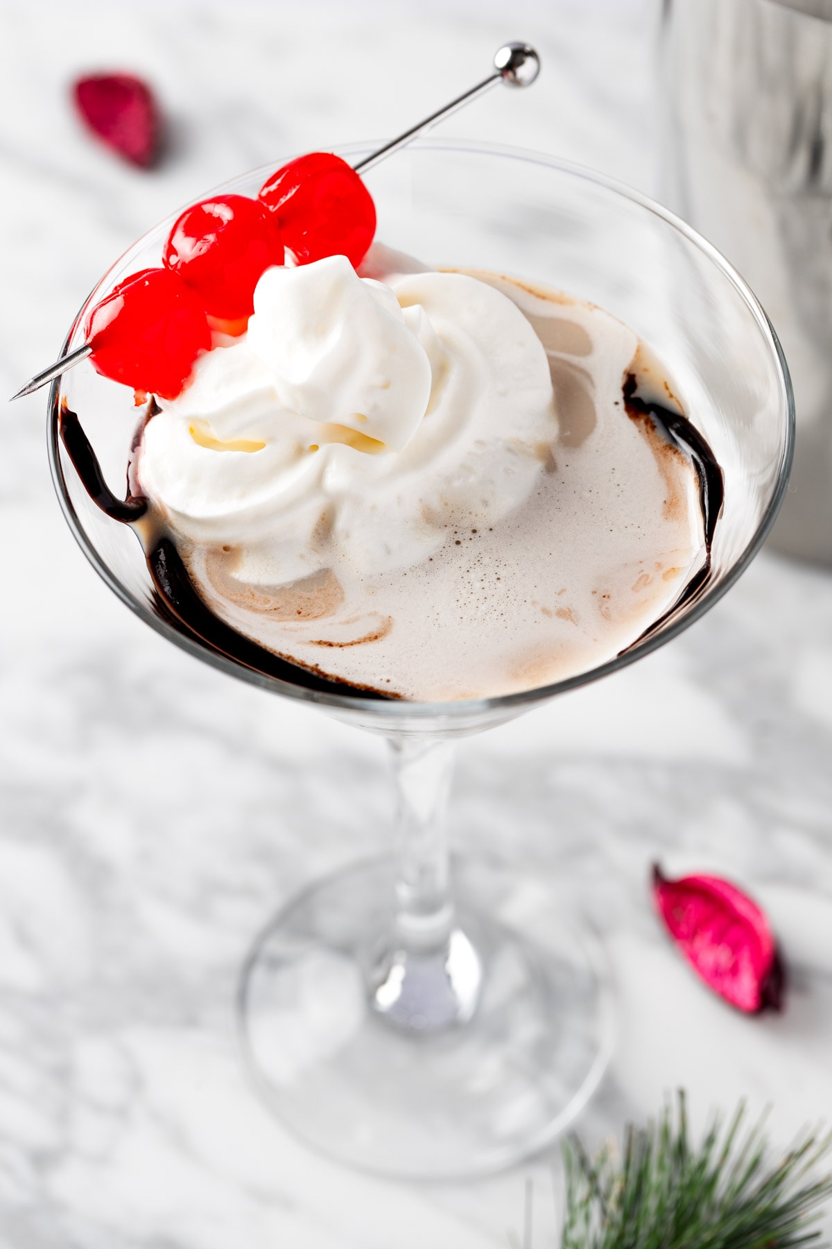 A cherry chocolate martini topped with whipped cream and maraschino cherries.