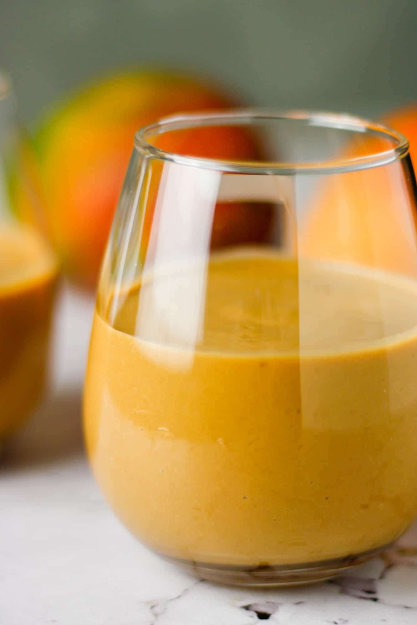 Up close view of a glass of chocolate mango smoothie on the table