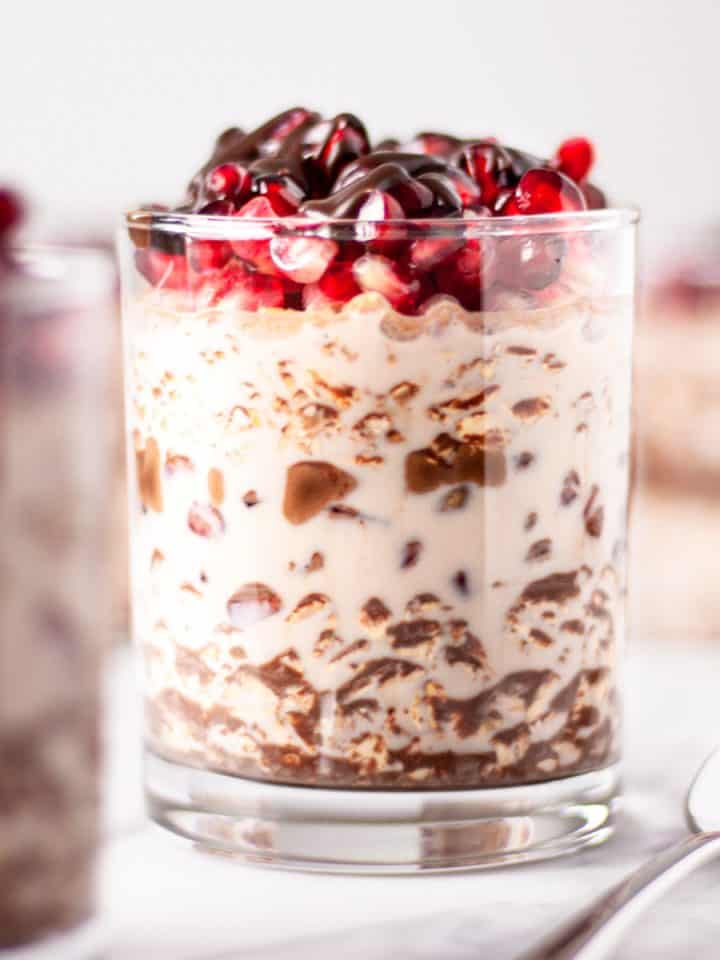 Up close view of a glass of chocolate pomegranate overnight oats
