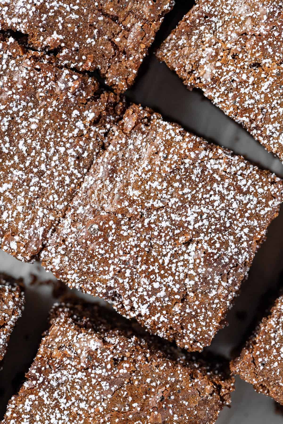 Up close overhead view of coffee brownies topped with a sprinkle of icing sugar.