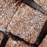 Up close overhead view of coffee brownies topped with a sprinkle of icing sugar.
