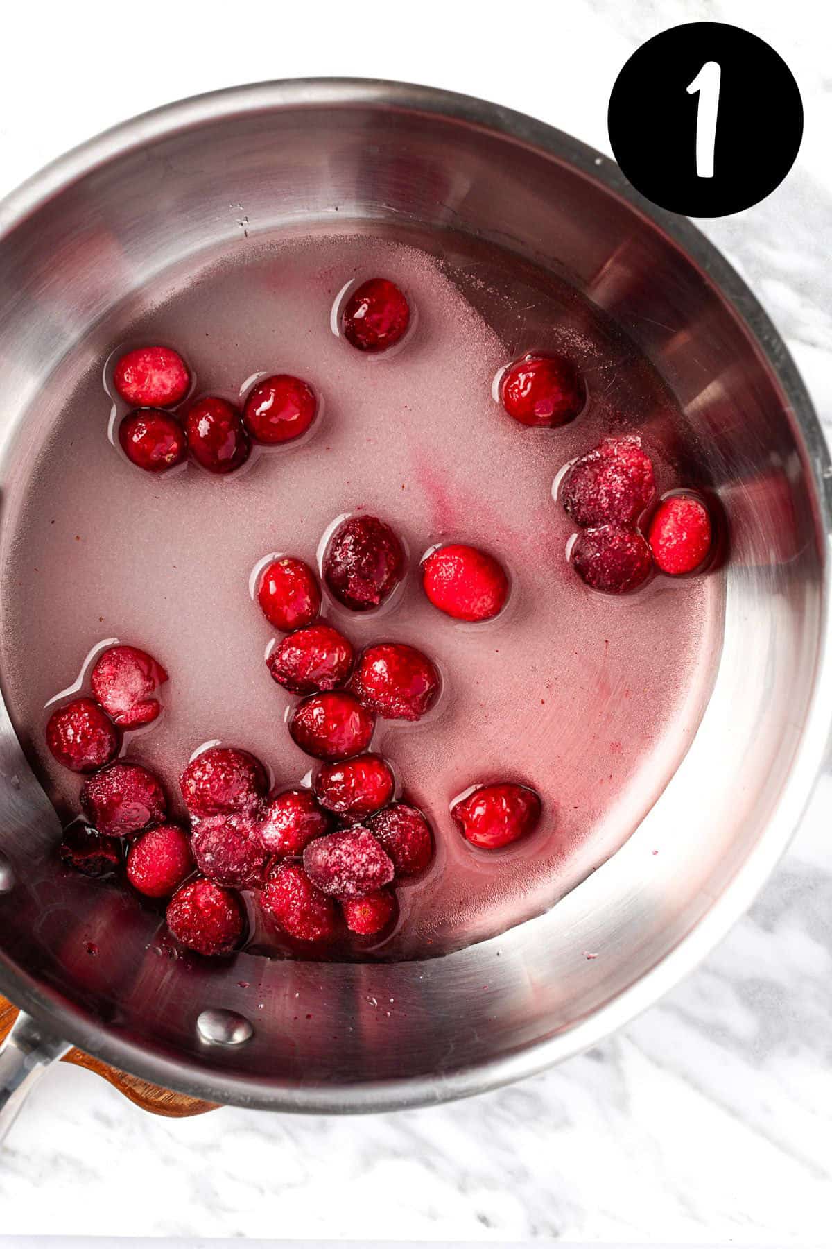 Step 1: Heating the cranberries, sugar and water in a saucepan.