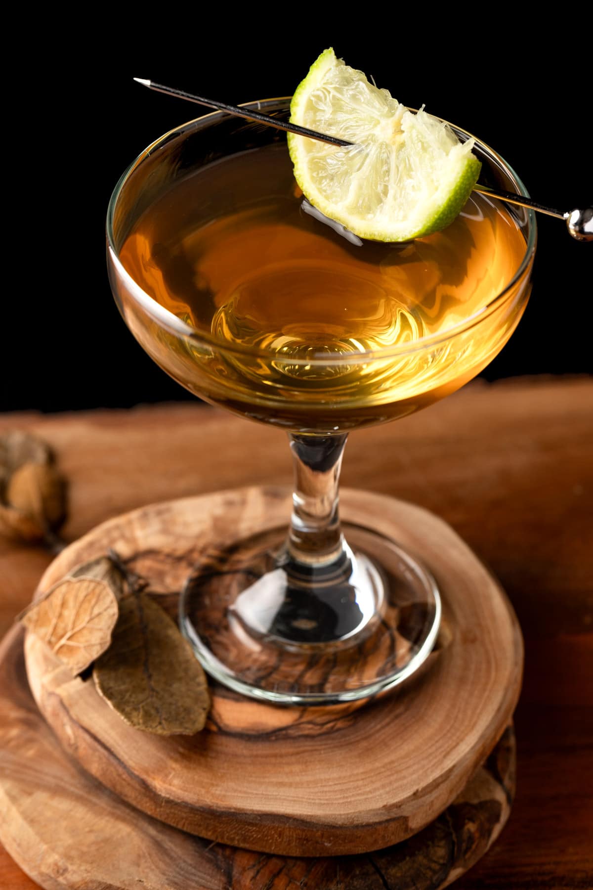 A dark rum daiquiri in a coupe glass on a wooden coaster.