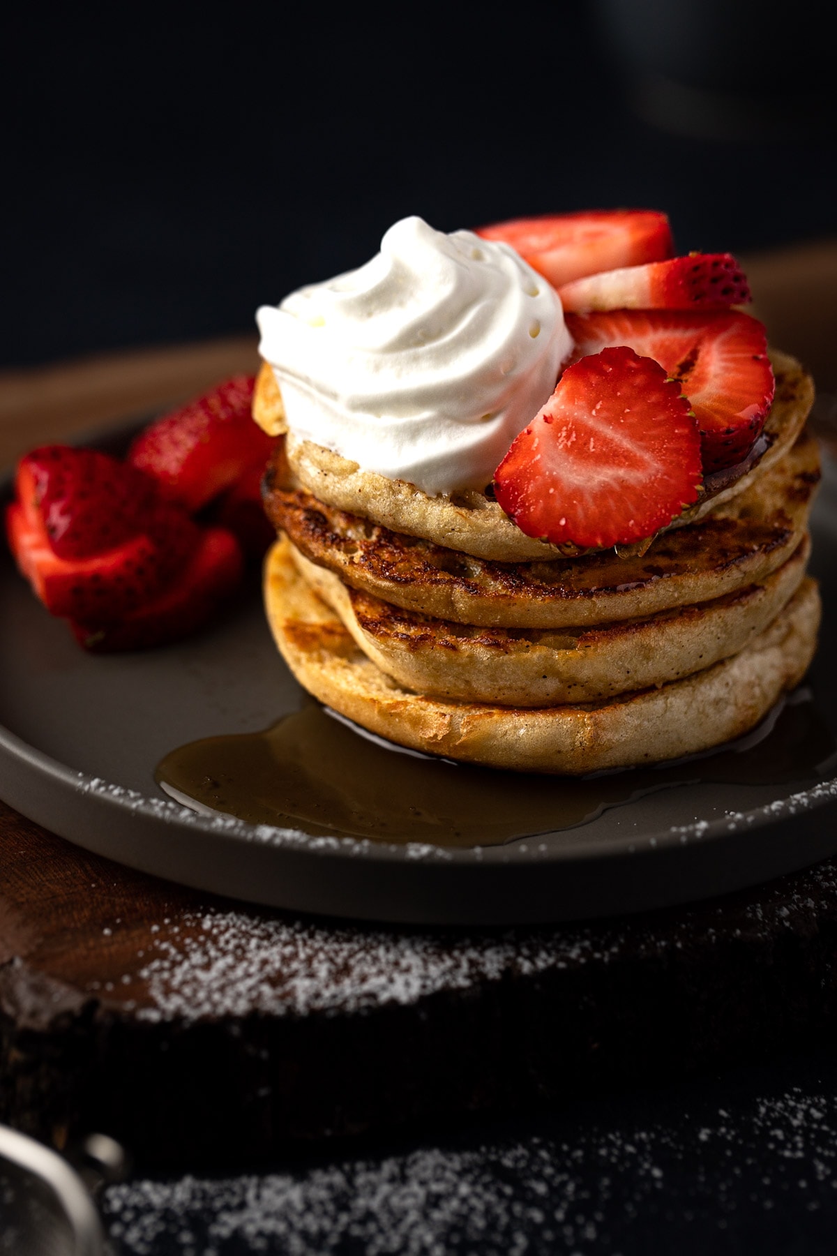A stack of English muffins topped with whipped cream and fruit.