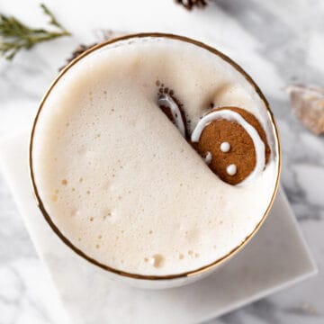 A Gingerbread Chai Latte with a gingerbread man cookie sinking in the drink.