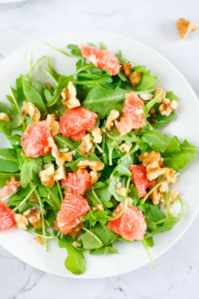 Overhead view of a bowl of arugula grapefruit salad