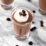 Kahlua Pudding Shots topped with whipped cream and coffee beans.