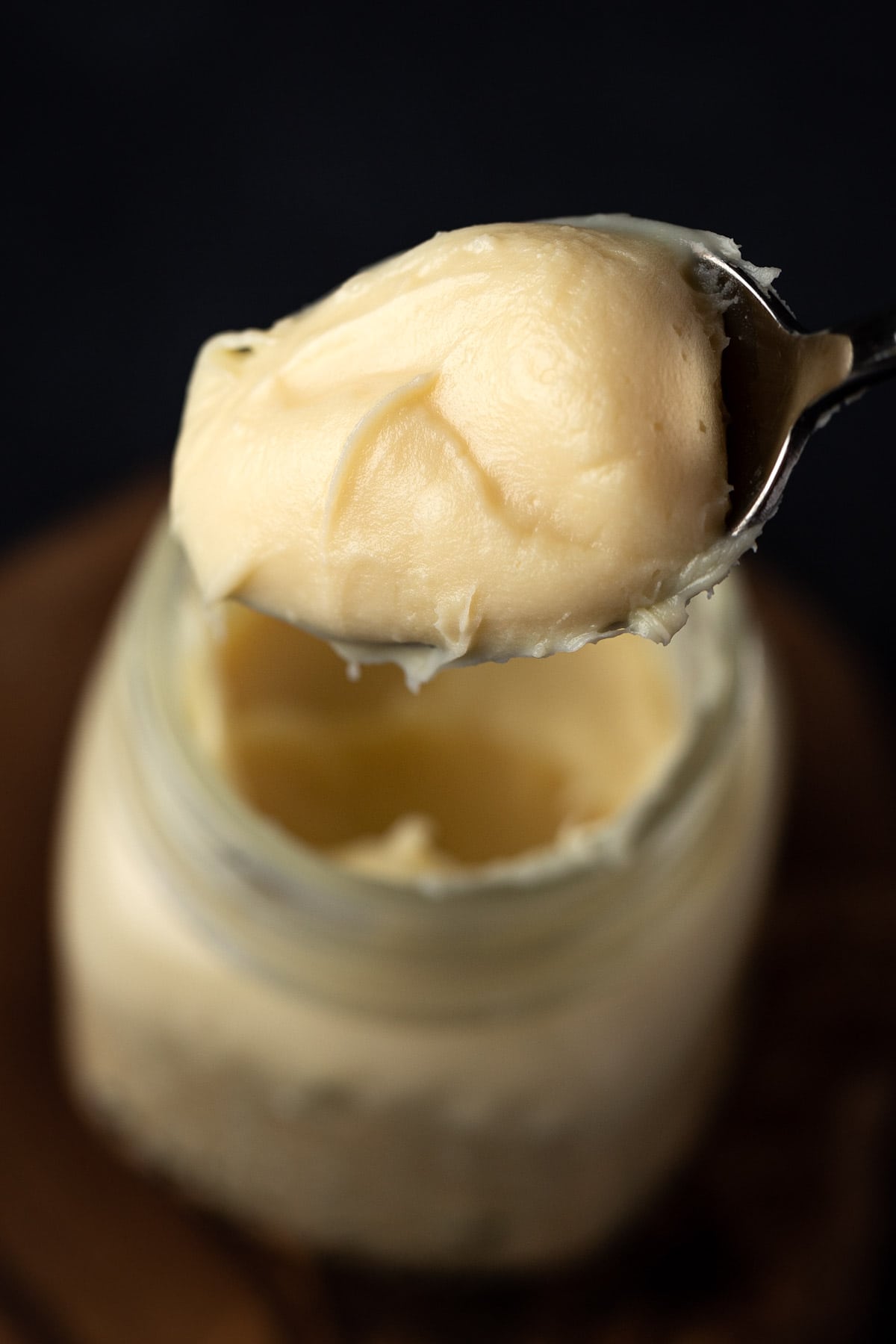 Close up view of a spoonful of yellow lemon ganache.