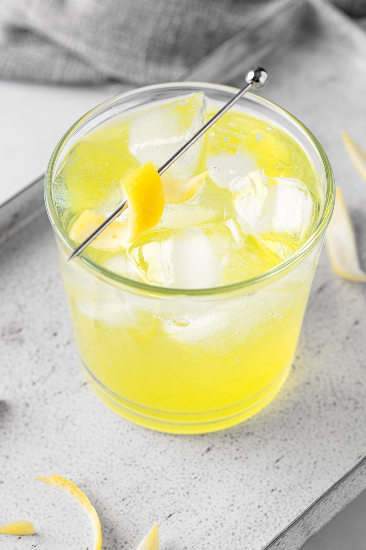 Overhead view of a limoncello tonic garnished with a lemon peel twist.