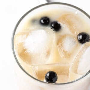 Overhead view of a lychee bubble tea with brown sugar syrup and black tapioca pearls.
