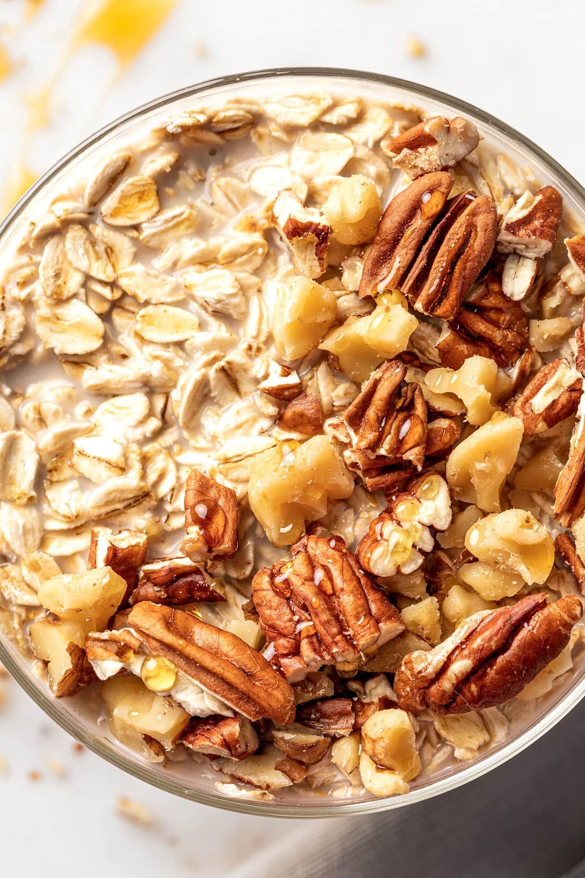 Up close overhead view of maple brown sugar overnight oats topped with toasted walnuts and pecans.