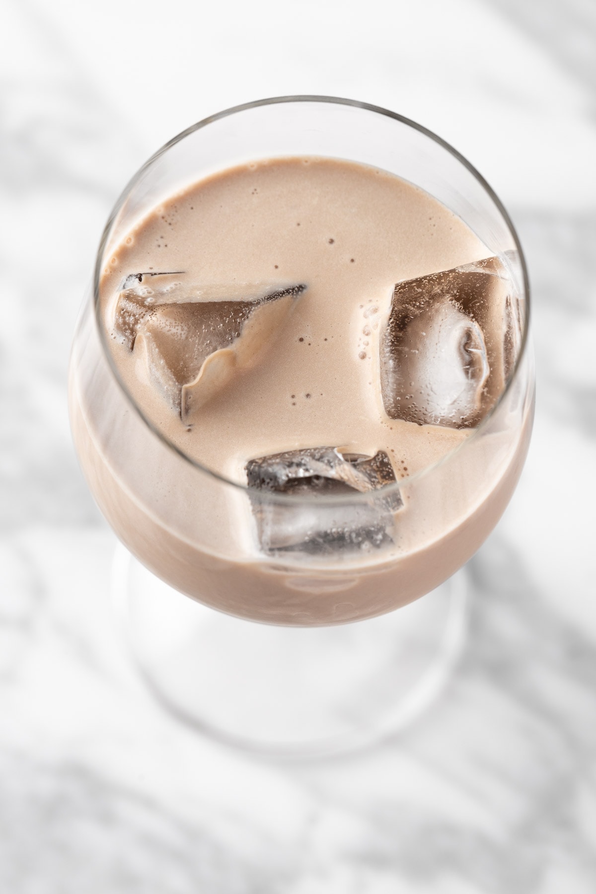 Overhead view of a non alcoholic baileys in a cocktail glass with ice.