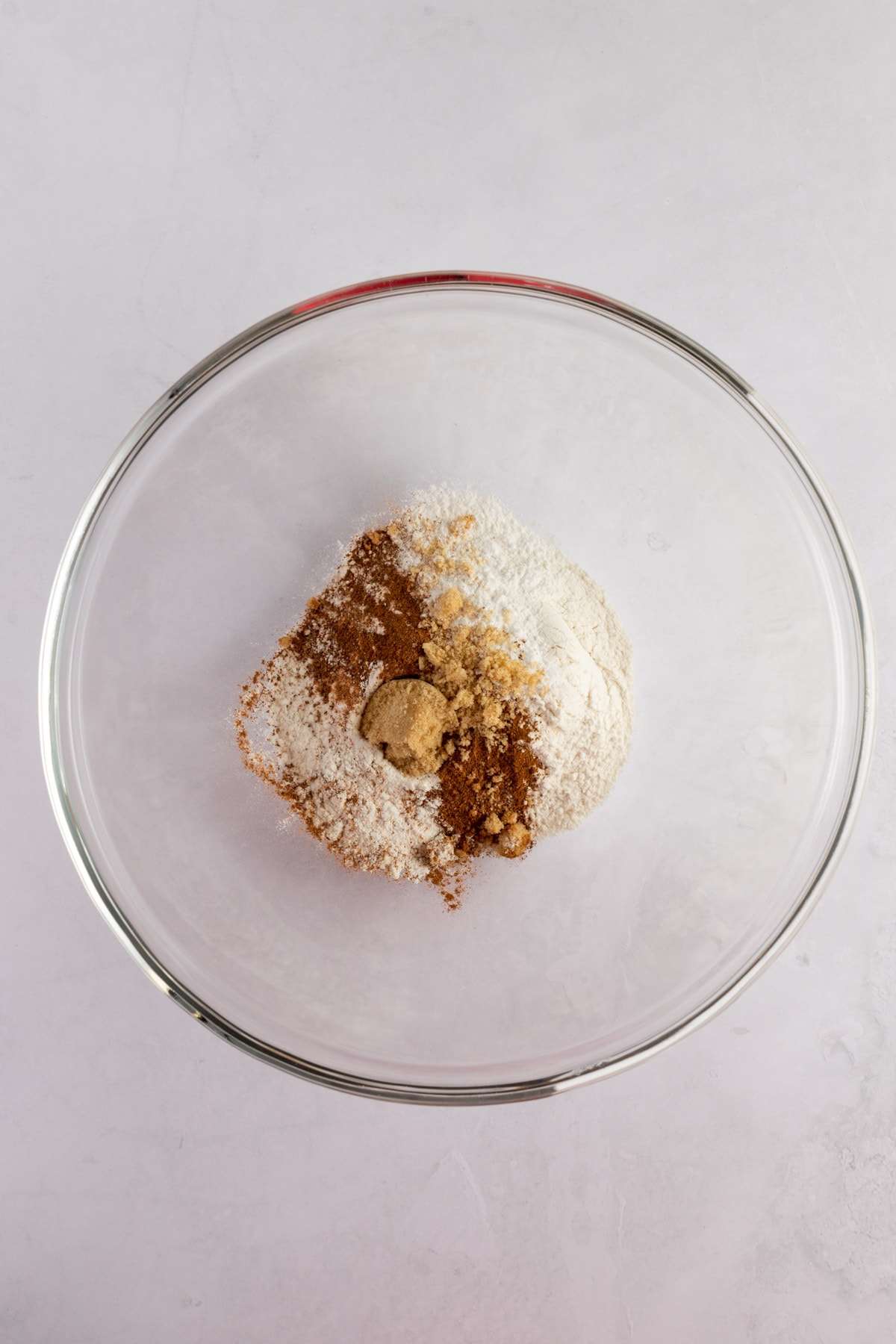 Overhead photo of the dry ingredients in a glass bowl on a white table.