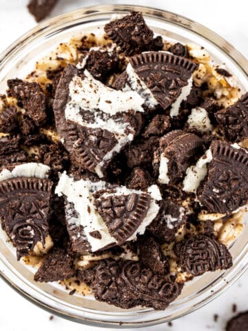 Oreo overnight oats in a small glass bowl, topped with chunks of Oreo cookies.