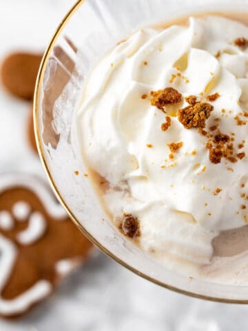 An Outback Gingerbread Martini topped with whipped cream and gingerbread cookie crumbles.