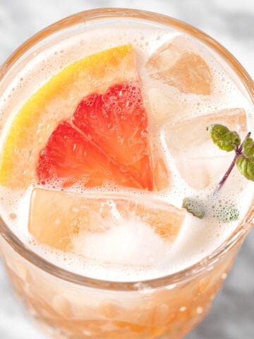 A paloma mocktail garnished with a slice of grapefruit and a sprig of mint.