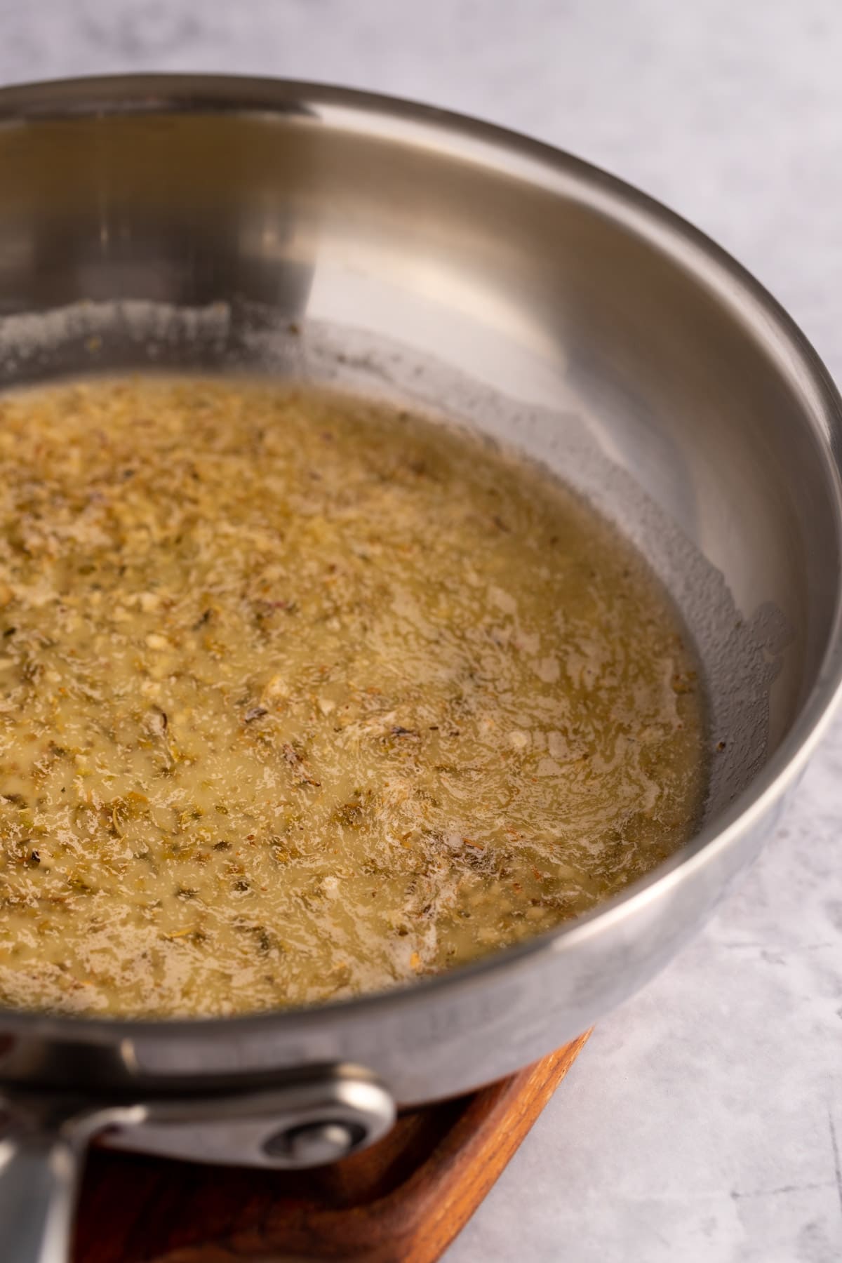 Metal saucepan filled with garlic butter sauce.