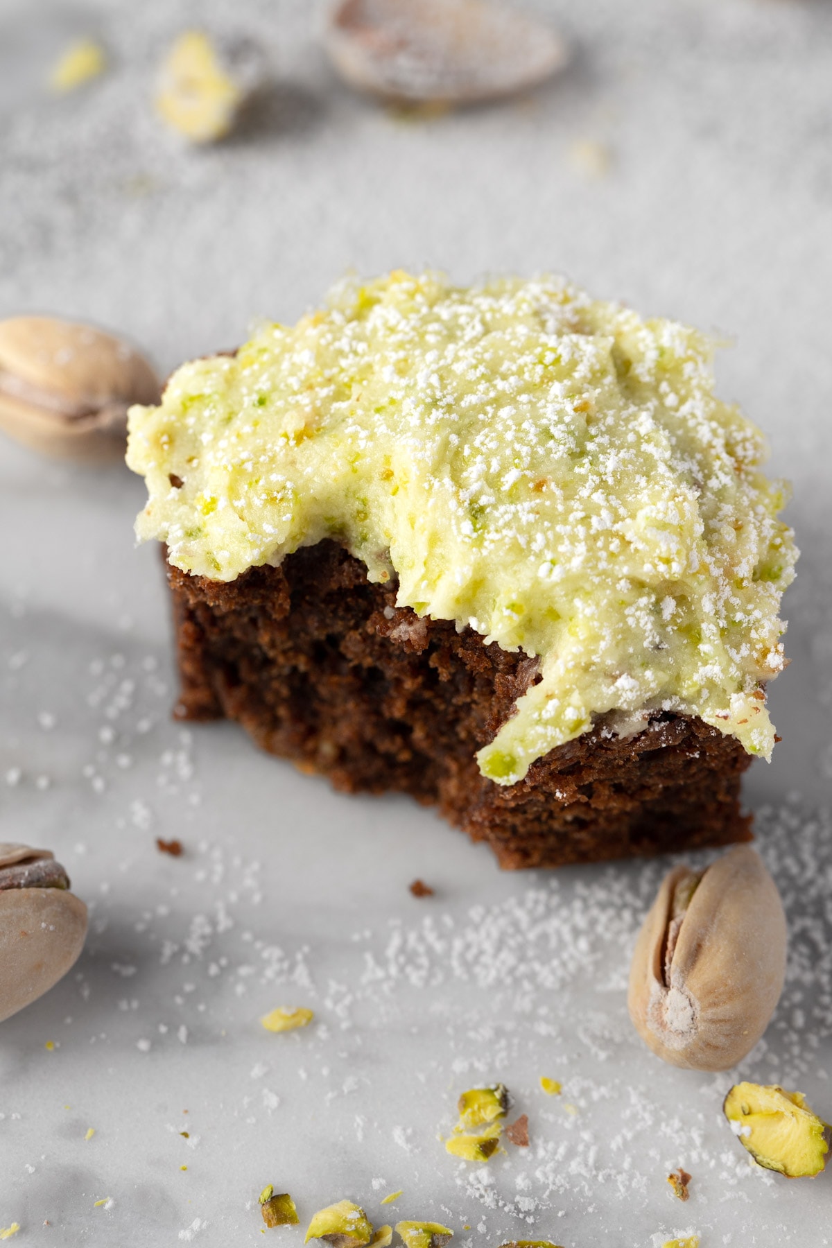 A chocolate brownie topped with pistachio frosting.