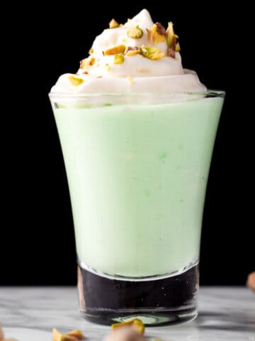 A green pistachio pudding shot on a black background.