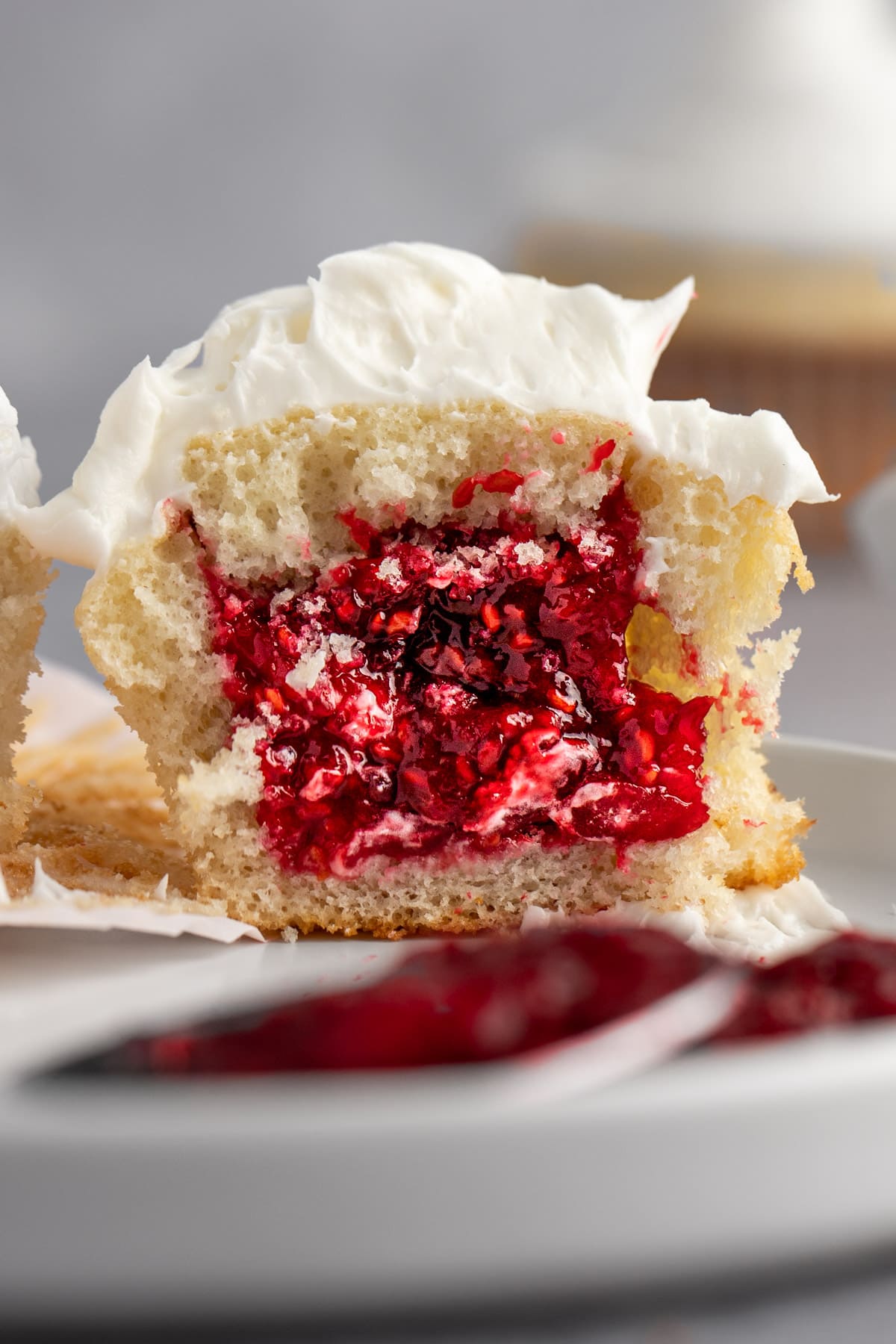 A cupcake cut in half, filled with raspberry filling.