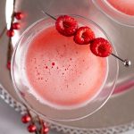 Overhead photo of a raspberry martini garnished with three raspberries.