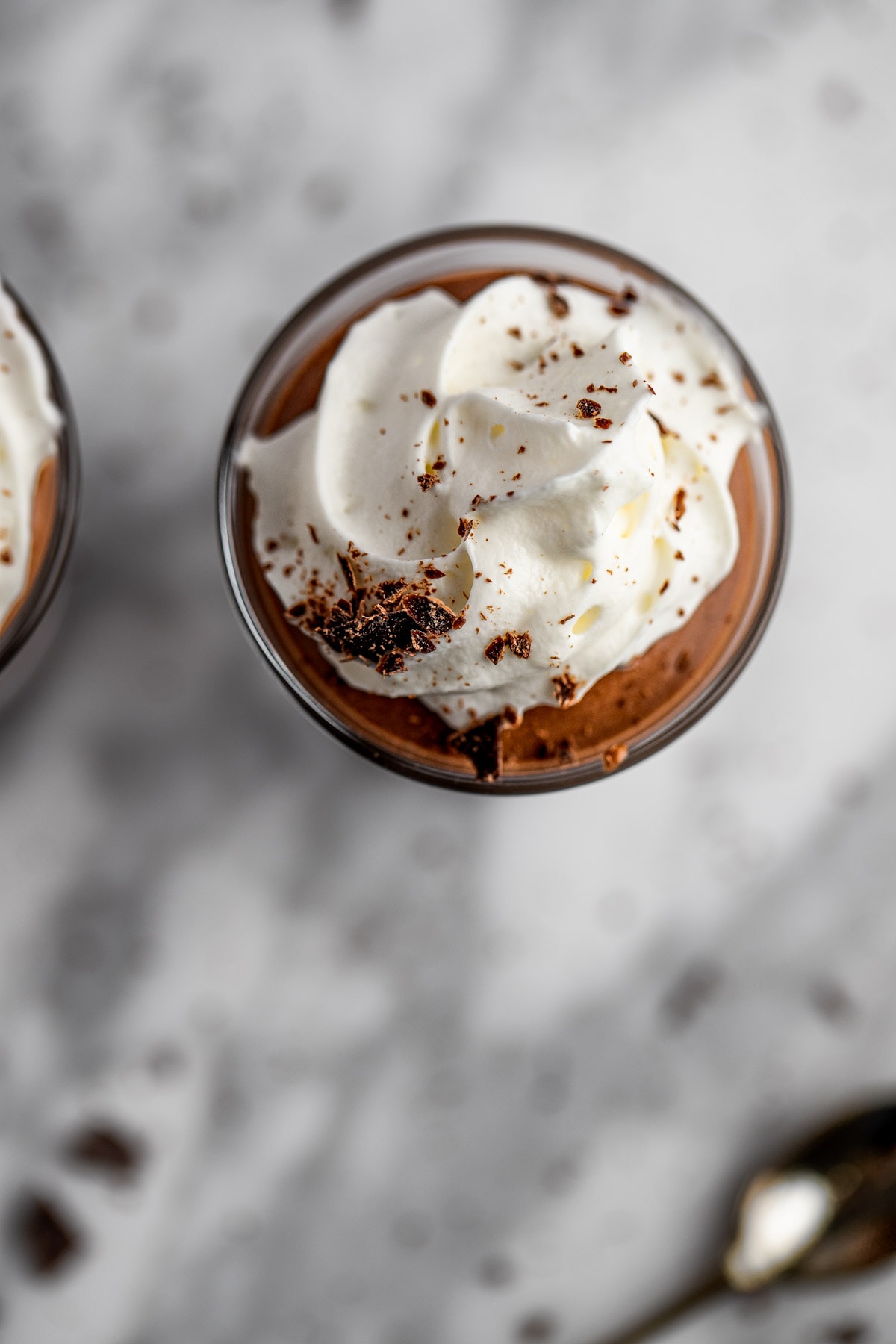 An overhead, up-close view of a rumchata shot topped with whipped cream.