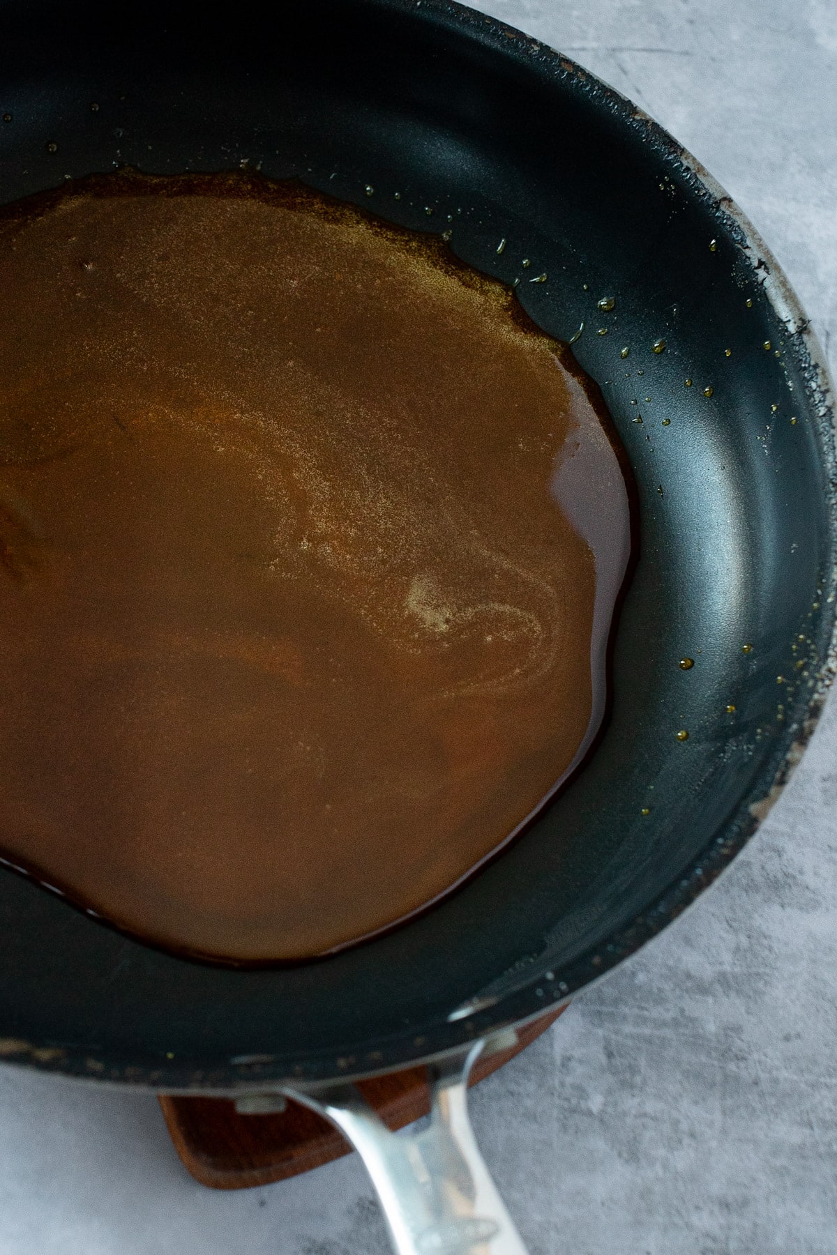Overhead view of salted caramel sauce in a black pan.