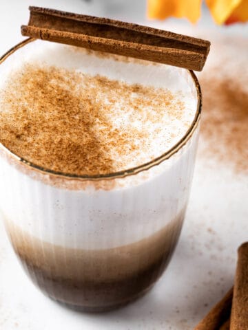 A Starbucks chai tea latte topped with a sprinkle of cinnamon.