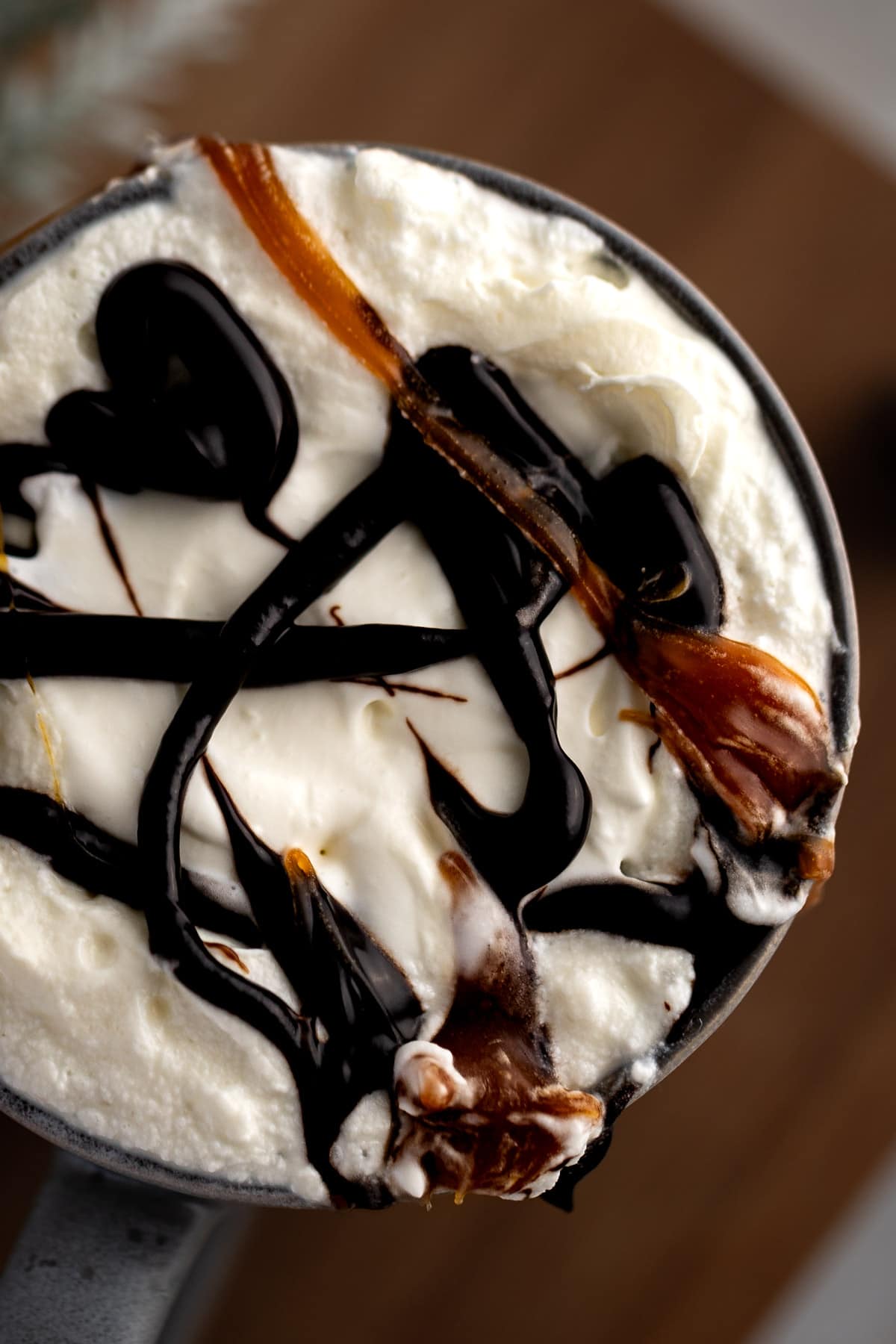Close up view of a salted caramel mocha with chocolate sauce and salted caramel syrup drizzled on top.