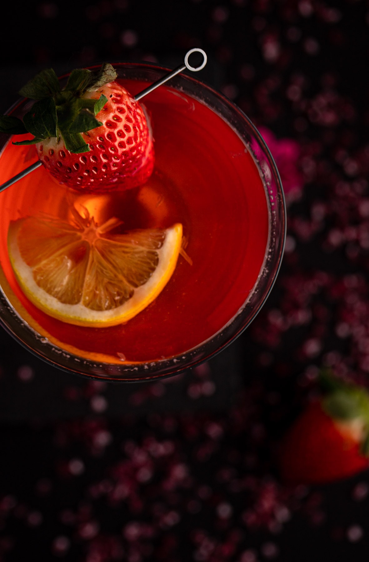 Overhead view of martini garnished with a strawberry and a slice of lemon.