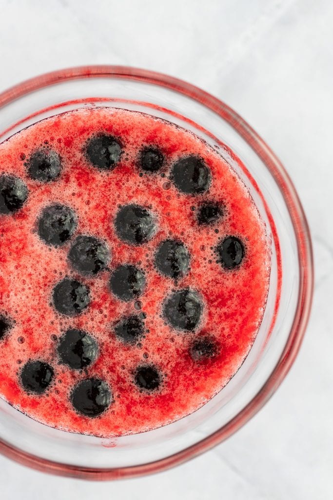 Overhead and up close view of cooked black boba mixed into the strawberry syrup.