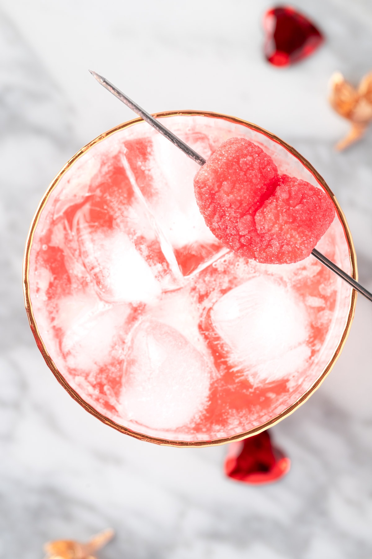 A pink Valentine’s Mocktail on a white marble table.