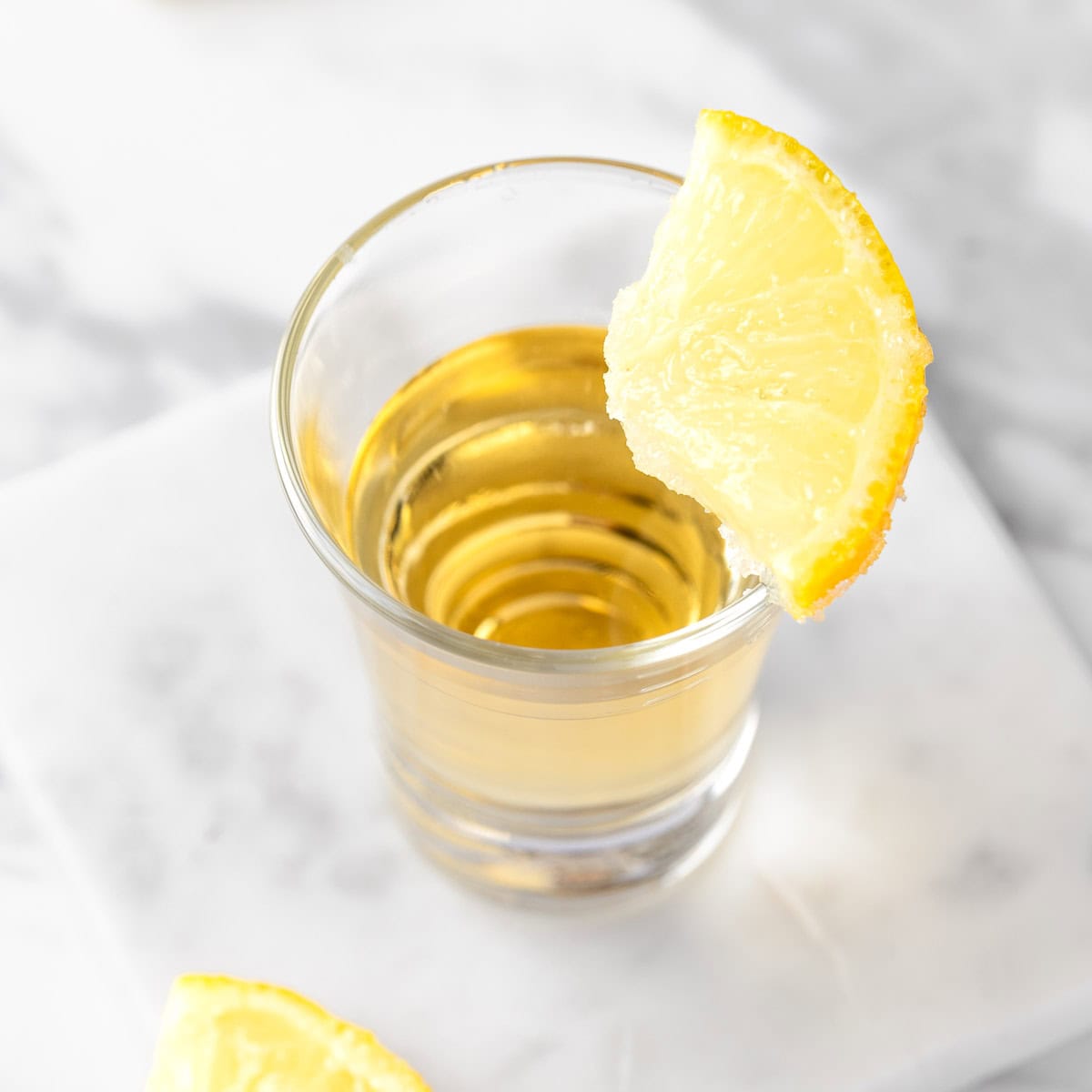 A wedding cake shot garnished with a slice of sugared lemon.