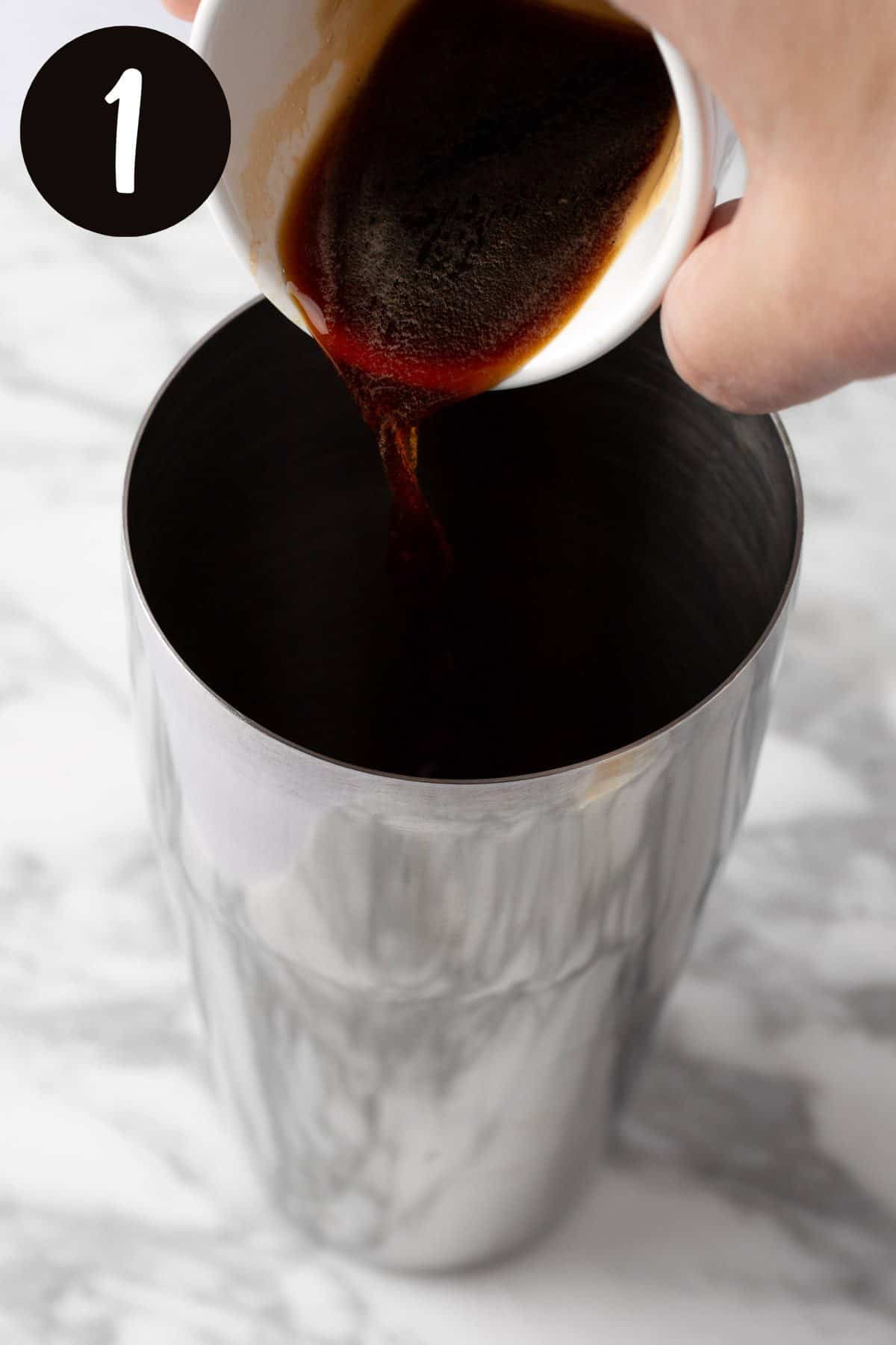 Pouring the espresso into a metal cocktail shaker.